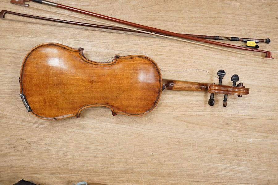 A late 19th century German violin, body 35cm long, and two bows. Condition - poor to fair.